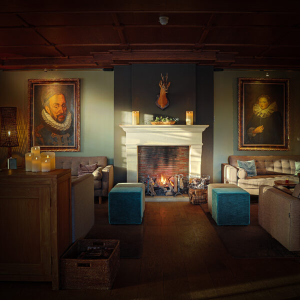 openhaard met schilderijen aan de muur in een woonkamer.