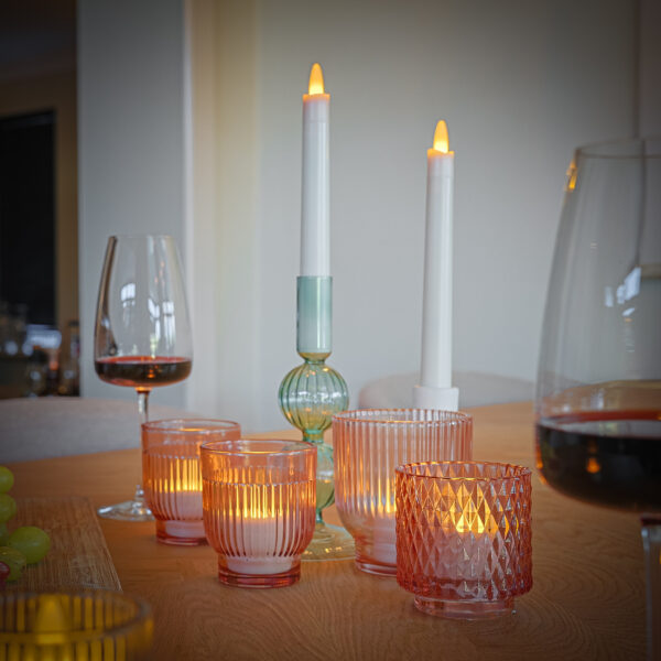 verschillende kaarsen met 2 wijn glazen op tafel