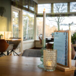 2 kaarsen met een menukaart in een restaurant