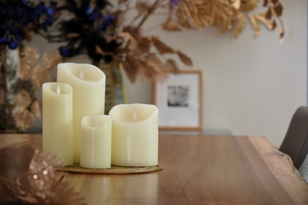 4 kaarsen van dorsetto op een tafel met gouden planten op de achtegrond