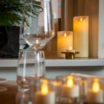 sfeerfoto kaarsen met afstandsbediening op tafel met wijnglazen