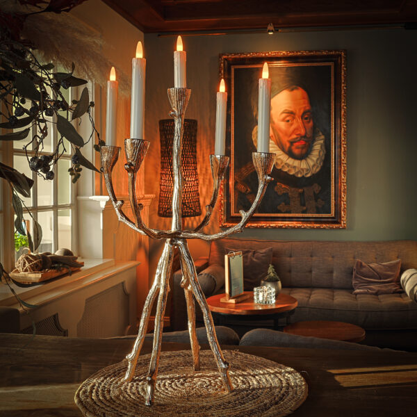 kaarsen in een kaarsen houder met een de muur een schilderij