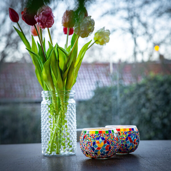 Gekleurde waxinehouder met veel verschillende kleuren op een tafel