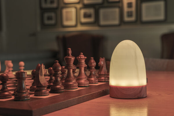 Een leeslamp van dorsetto naast een houten schaakboord