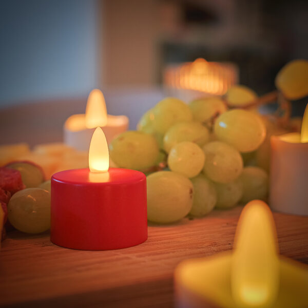 rood waxinelichtje met groene druiven op een houden tafel
