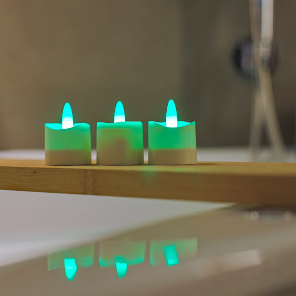 3 groene waxinelichtjes op een plank